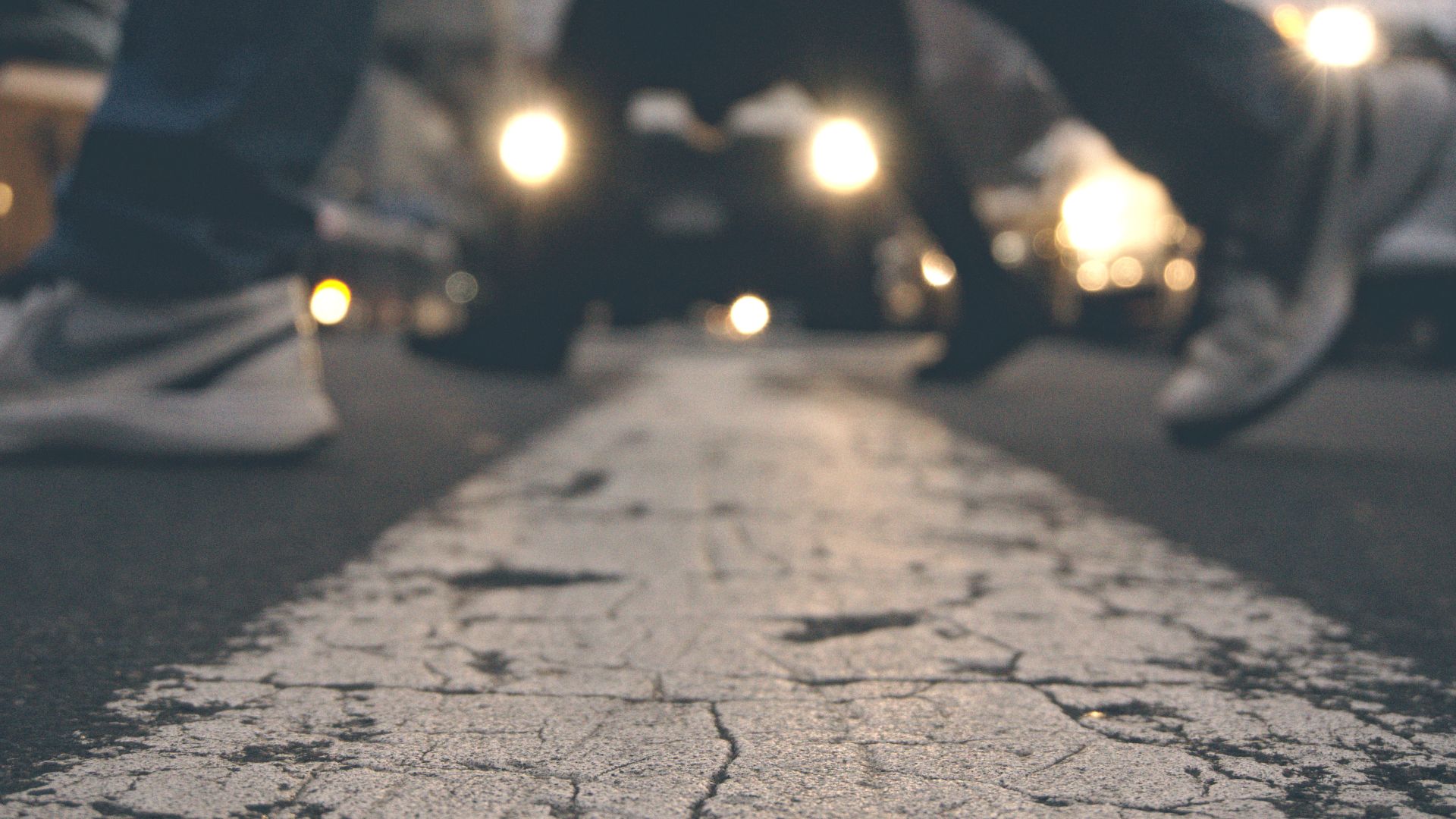 Personas caminando sobre un cruce peatonal, fotografiadas a nivel del suelo