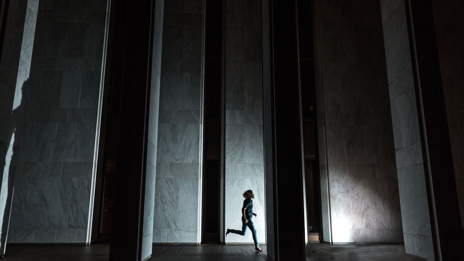 Una persona corriendo entre grandes columnas